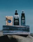 Ninth Wave Body and Face Essentials kit displayed on its box at the beach
