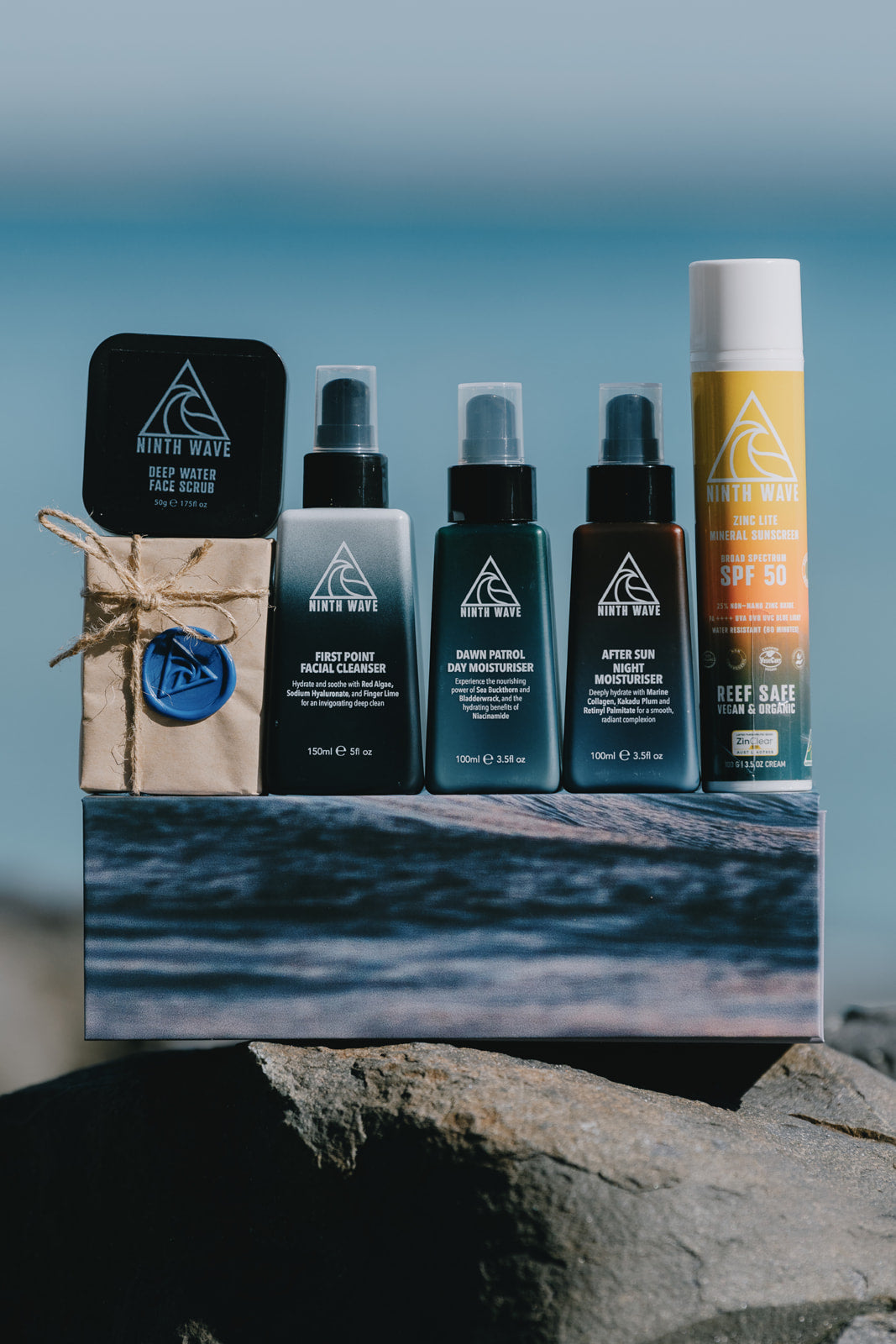 Ninth Wave Complete Sun Recovery System arranged on a rock at the beach to highlight its surf and sun recovery roots